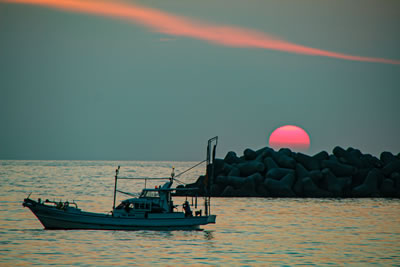 沈む夕日と漁船